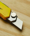 FatMax Snap Off Knife Durable Utility Knife with 25mm blade, ergonomic yellow grip, shown on wooden surface