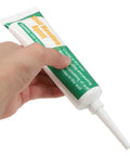 Hand squeezing tube of Drywall Repair Putty Paste For Quick Hole Patching And Wall Mending Cream Safe Ingredients Easy No Mess Smoothing Smear On Spackle