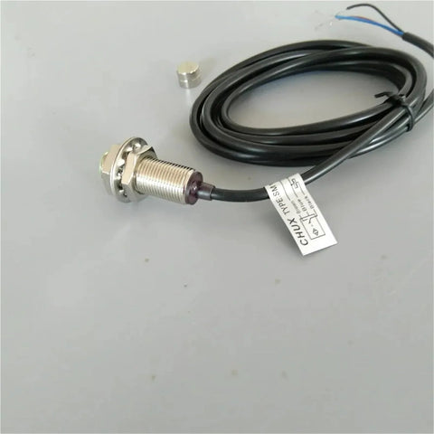Front view of Amazon M12 magnetic switch sensor with threaded metal housing, mounting nut, and black cable