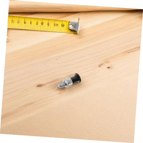 Build Tough Stainless Steel Spring Plunger With Fine Thread Reset Action And Rock Solid Self Locking Grip on wooden surface with measuring tape.