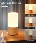 Cozy Beech Wood Table Lamp With Dimmable LED Light displaying adjustable brightness levels on a bedside table.