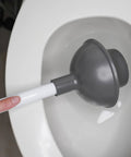 Heavy Duty Toilet Plunger With Extended Flange And Portable Caddy in toilet, gray cup, white handle for stubborn clogs.