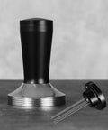 Pro Grade 58 Millimeter Espresso Tamper Plus Five Pin Coffee Distributor Needle Tool Two In One Ground Press Barista Kit on countertop.