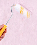 A person using the Slick 10 Piece Mini Paint Roller Covers Heavy Duty Acrylic Dripless Wall Wood Fabric Decorating Kit on pink wall.