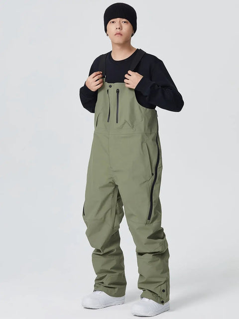 Man wearing army green waterproof ski bibs for outdoor sports, showcasing the Waterproof Ski Bibs Men Winter Snow Pants Overalls Snowboarding Outdoor Sports Breathable High Stretch All Day Warmth and Mobility Winter Gear Built to Handle Cold Days Durable Windproof.