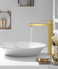 Gold Vessel Sink Faucet in Brushed Gold Finish installed beside a white vessel sink on a bathroom counter