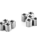Front view of ten silver metal threaded inserts with ridged exterior and internal threads