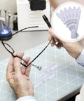 6-Piece Pupillary Distance Ruler Set for Eyeglasses Fitting, PD Meter Kit, Lightweight Flexible Plastic Eye Tool, 7.08 Inch, Perfect for Precise Pupillary Measurements at Home or Clinic. Hand holding eyeglasses with PD rulers on table