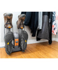 Heavy Duty Electric Shoe And Boot Dryer With Convection Heat Sweeps Moisture Out Of Work Boots And Ski Gear Four Port Quick Dry Cycle Kills Stink For Garage And Home Use with dirty boots attached.