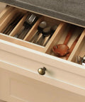Open drawer with cutlery organized inside, featuring Six Pack Antique Brass Cabinet Knobs With Layered Edge Detailing Classic Round Drawer Pulls.