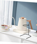Grab A Fresh Cup With This Premium Solid Metal Coffee Dripper Stand on a countertop with a coffee cup and kettle.