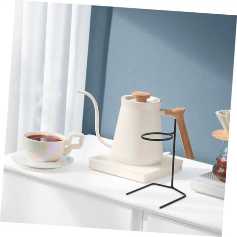Grab A Fresh Cup With This Premium Solid Metal Coffee Dripper Stand on a countertop with a coffee cup and kettle.