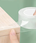 Solid Go To Clear Edge Protector Tape, 1.5 Inch X 6.6 Feet, Self Adhesive Furniture Bumper Guard Strips For Cabinets And Counters being applied on a wooden edge.
