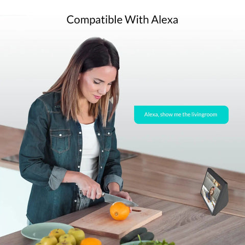 Woman using voice control with Alexa device while preparing food in kitchen, demonstrating Indoor Security Cam 1080p HD WiFi 2.4GHz compatibility.