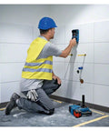 Worker using Hardcore Stud Finder Wall Scanner Boasting Dead On Rebar And Wire Detection on tiled wall.