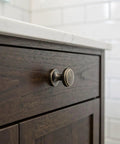Close-up of a brushed zinc alloy knob on a dark wood drawer, part of a 4 Pack Brushed Zinc Alloy Cabinet Pulls Single Hole Drawer Handles For Kitchen Cabinetry Bedroom Dresser Bathroom Vanity Wardrobe Hardware.