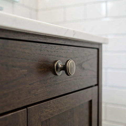 Close-up of a brushed zinc alloy knob on a dark wood drawer, part of a 4 Pack Brushed Zinc Alloy Cabinet Pulls Single Hole Drawer Handles For Kitchen Cabinetry Bedroom Dresser Bathroom Vanity Wardrobe Hardware.