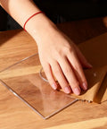 Lotus Flower Acrylic Router Template Seven Nine Inch Square Dead On Clear Floral Inlay Guide held above wooden surface.