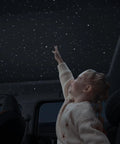 Child enjoying Starry Sky Car Projector And Diffuser With Air Freshener, Ceiling Ambient Light.