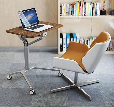 Game Changer Height Adjustable Standing Desk With Silky Gas Lift And Ultra Quiet Lockable Rubber Wheels beside a modern swivel chair.