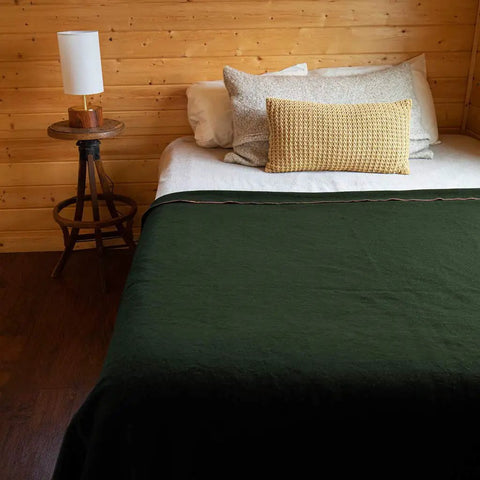 Olive bed with Beefy Warmth And Rugged Durability Military Wool Blanket for outdoors camping picnics travel stadium events and survival kits.