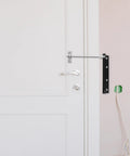 Automatic Door Closer For Home And Gate Black Stainless Steel With Rebound Closing And Anti Rust Feature on white wooden door