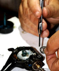Applying Black Fishing Reel Grease 2 Oz for Smooth Casting and Maintenance on a disassembled reel to ensure superior lubricity and rust protection.