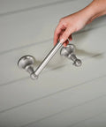 Vale Brushed Nickel Double Post Pivoting Toilet Paper Holder being installed, showcasing spring free pivoting design.