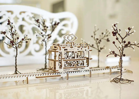 Tram With Rails 3D Puzzle Kit, Self Propelled Mechanical Wooden Model For Adults And Kids, Hands On Learning Mechanics, Build It, And Watch This Tiny Vehicle Cruise Rails. Wooden tram on rails, shown in a model scene