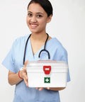 Milton white plastic first aid box, front view with red latch and green cross logo held by nurse