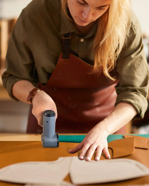 Person using Cordless Electric Scissors Upgraded 4V Rotary Cutter With Two Blades And LED Light to cut fabric on table.