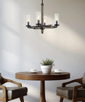 Alden 18 Inch 4 Light Modern Farmhouse Chandelier with clear glass shades, gray oak wood finish, and black accents over table.