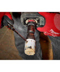 Milwaukee 4-inch ice-hardened hole saw cutting white PVC pipe; close-up view.