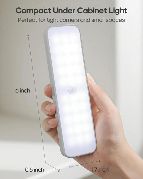 Hand holding a 6-Inch Wireless Under Cabinet Light, compact design, rechargeable with motion sensor, ideal for small spaces.