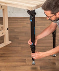 Man adjusting folding leg of Folding Top Extension Kit for Workbench, Space Saving Expansion that Adds a Large, Stable Work Surface
