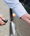 Person using retractable keychain to unlock car door, showcasing Five Pack Retractable Keychain Badge Holders With Steel Wire Reel Clip Durable ID Badge Reels For Lanyards Heavy Duty Retractable Reels Black Ideal For Office School Security Access.