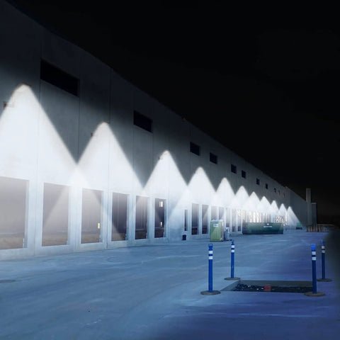 Nighttime view of lights installed using Beefy Heavy Duty 90 Degree Wall Mount Bracket With 2-3/8in OD Tenon on a warehouse wall.