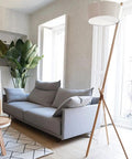 Living room with Whimsical Woodland Fantasy Peel And Stick Wallpaper In Cream And White, grey sofa, and modern lamp.