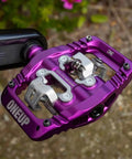 Purple mountain bike clip pedal attached to crank arm, featuring an SPD-compatible, extra large DH-sized platform for grip and fewer strikes.