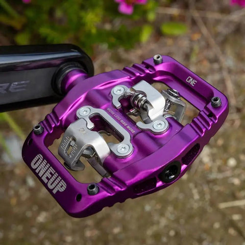 Purple mountain bike clip pedal attached to crank arm, featuring an SPD-compatible, extra large DH-sized platform for grip and fewer strikes.