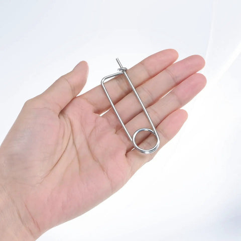 Hand holding a 2x45mm brooch-shaped cotter pin from the 8 Pack Brooch Shape Cotter Pins With Quick Lock Fasteners set for outdoor use.