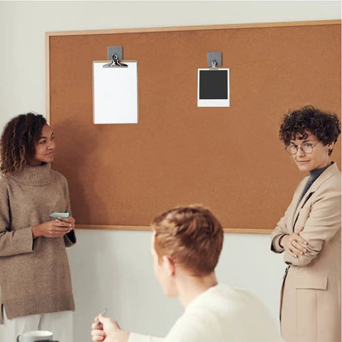 Office setting showing Four Pack Fabric Wall Cubicle Hooks Heavy Duty Stainless Steel Mounts on a cork board with papers. 50 Pound Load Black.