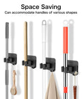 4 Pack No Drill Self Adhesive Broom Mop Holder Wall Mount With Hooks holding various cleaning tools on a wall