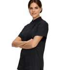 Women Short Sleeve Chef Coat In Sleek Black Legit Culinary Jacket With Heavy Duty Cotton Poly Blend worn by smiling model.