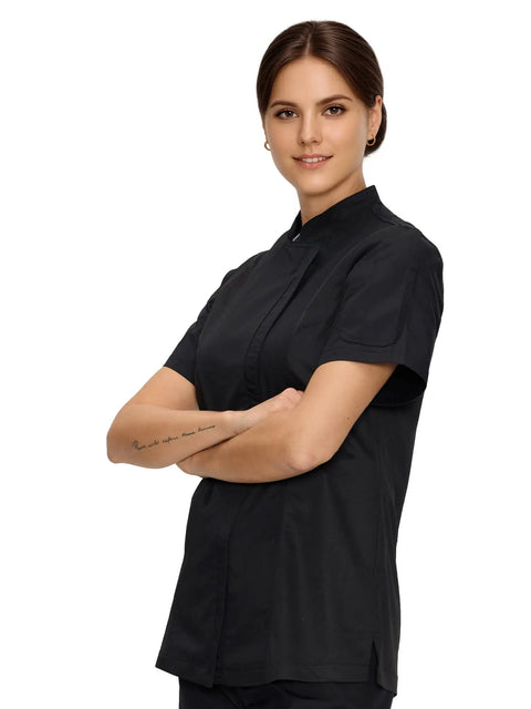 Women Short Sleeve Chef Coat In Sleek Black Legit Culinary Jacket With Heavy Duty Cotton Poly Blend worn by smiling model.