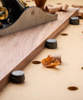 Wood plane on workbench with Spaced Dog Hole Router Template for precise holes and bench tools like dogs and cookies.