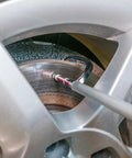 Brake Disc Thickness Measurement Verniers Caliper measuring brake disc through car wheel, with a visible aluminum body and gauge.