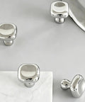 Slick Silver Cabinet Knobs and Drawer Pulls Set, Polished Zinc Alloy With Titanium Coating, square knobs on gray surface