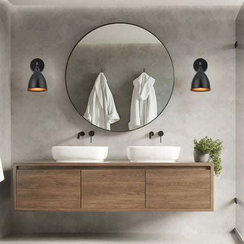 Set Of 2 Matte Black Bell Shade Wall Sconces With Switch, illuminating a modern bathroom with double sinks and round mirror.