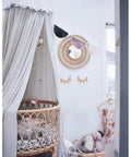 Kids Bed Canopy Tent With Frills Cotton Hanging Net in soft grey over wicker crib in cozy playroom setting